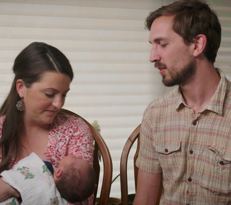 Image of mother and father holding their baby